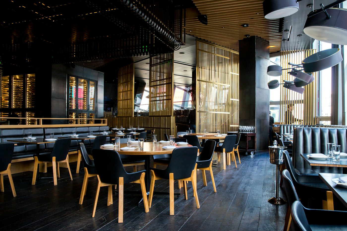 Interior restoran dengan meja kayu dan cahaya hangat
